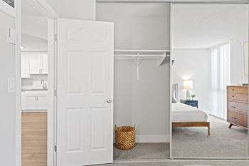 A bedroom with a closet and a white door